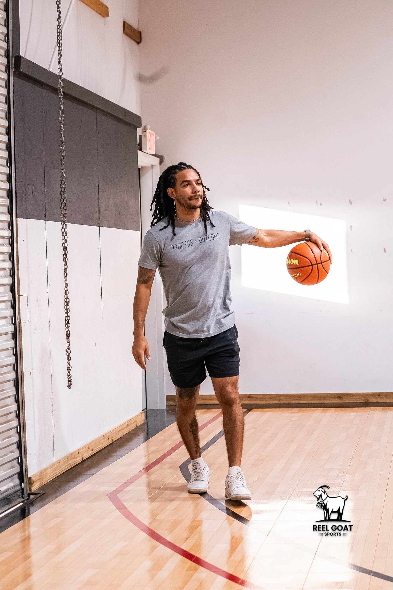 Jalen Harris standing on a basketball court holding a basketball
